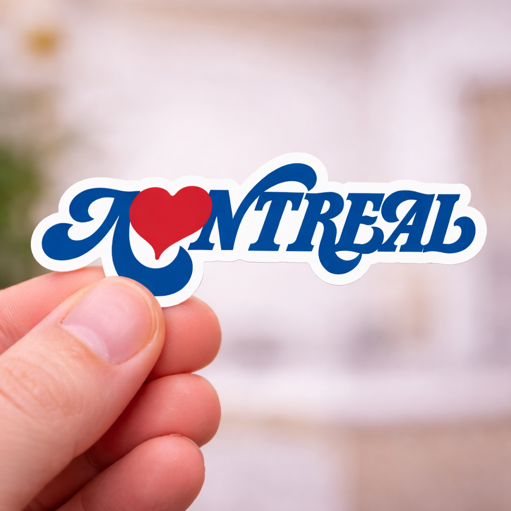 Hand holding montreal love sticker with a blurred background