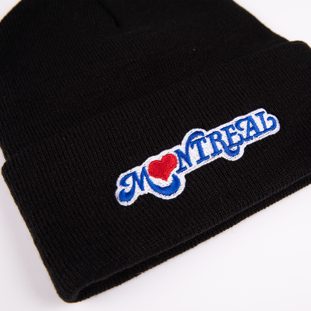 A closeup of a black tuque with the Montreal Love design embroidered on the front. 