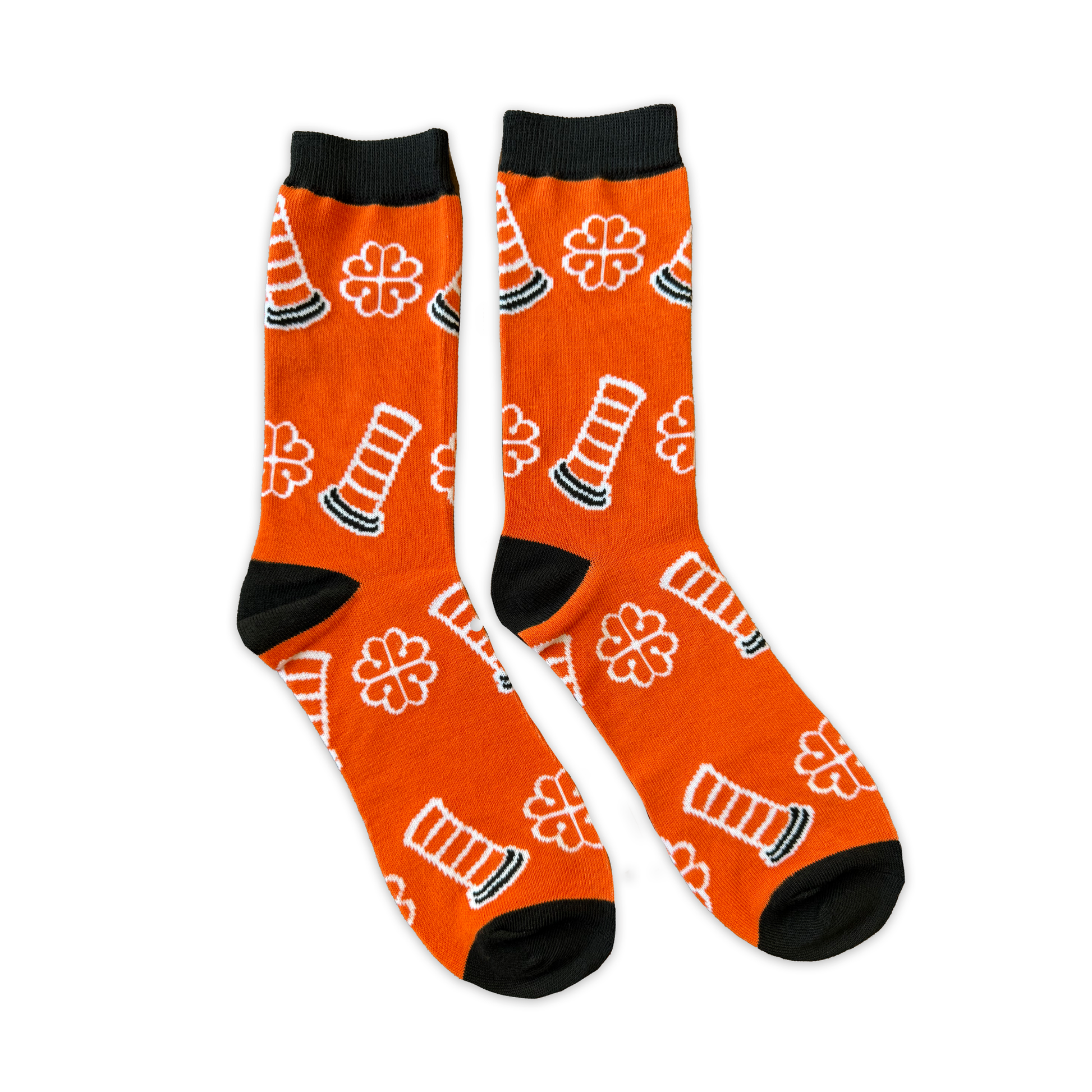 Two socks on a white background. They are orange with designs of traffic cones and the Montreal city logo in white. 